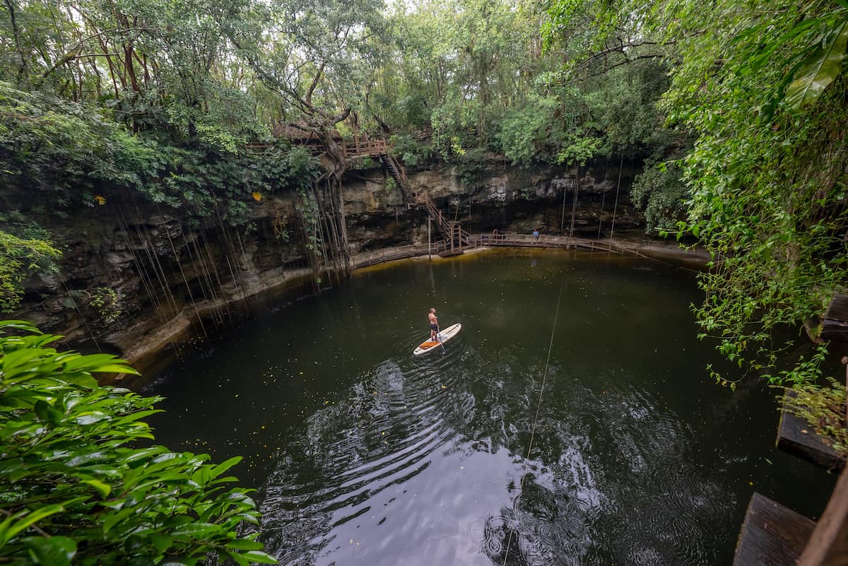 Paddleboarder on Thurso Surf Waterwalker demonstrates how to paddle a lush jungle cenote in the Yucatan paddling in the center