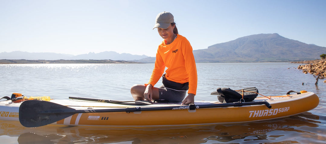 Woman sits on a paddleboard in the water