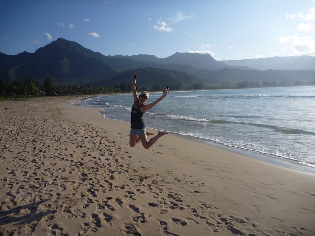 Woman jumping on the beach in Kauai